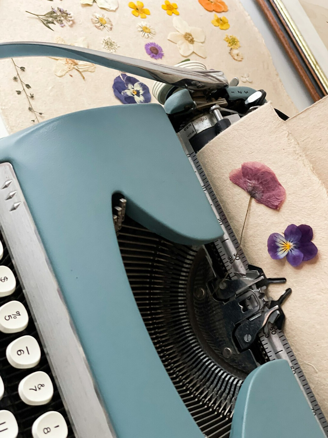 Vintage typewriter with a blank page and scattered handwritten notes on a wooden table